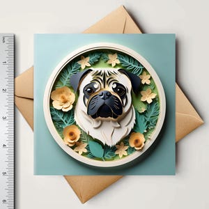 May include: A square greeting card featuring a pug's face in a circular frame with floral and leaf accents. The card is on a light blue background, with a brown envelope underneath. The ruler shows the card is approximately 4 inches wide.