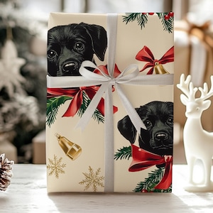 May include: Gift-wrapped present featuring a repeating pattern of black Labrador puppies, red bows, and gold bells on a cream background. The gift is tied with a silver ribbon and bow, perfect for Christmas or other special occasions.