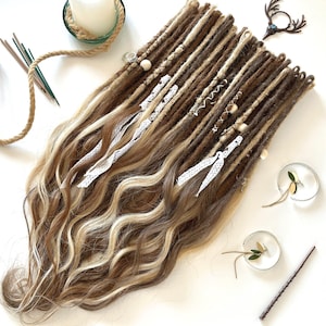 May include: Brown and blonde synthetic dreadlocks with white lace accents and wooden beads. The dreadlocks are arranged in a straight line and are ready to be installed.