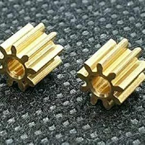 May include: Two gold-coloured metal gears with a 12-tooth design. The gears are small and have a smooth, polished finish.