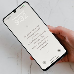 Puede incluir: Un teléfono inteligente blanco con una pantalla negra que muestra una cita sobre el amor y el perdón. La hora es 9:32 y la fecha es domingo 17 de diciembre. El texto en la pantalla dice: "Dios, concédeme que no busque tanto ser consolado como consolar, ser comprendido como comprender, ser amado como amar. Porque es en dar que recibimos, es en perdonar que somos perdonados."