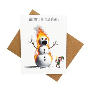Carte de voeux de Noël Elf allumant un bonhomme de neige en feu [Légende : Vœux les plus chaleureux pour les Fêtes] - Livrée avec enveloppe
