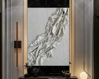 May include: A black and white marble console table with a gold metal frame. The table has a white textured wall art above it with a black marble background. There are two gold wall sconces on either side of the wall art.