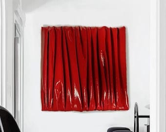 May include: A black modern chair with a curved back and seat sits in a room with white walls and a red abstract art piece on the wall.