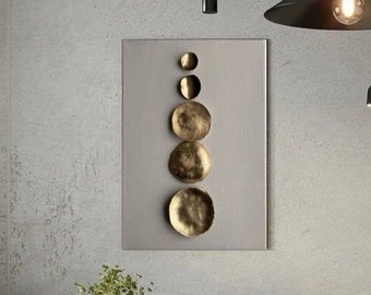 May include: A white curved sofa with a white fluffy throw pillow sits in front of a wall with a modern abstract art piece featuring gold circles. A round coffee table with a wooden base sits in front of the sofa.
