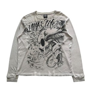May include: A long-sleeved, light grey t-shirt with a black and white graphic print of a skull with wings and the text "MMA Elite".