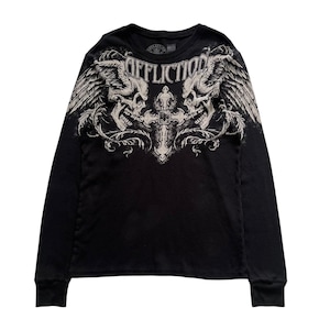 Puede incluir: Camiseta negra de manga larga con un diseño gráfico que presenta dos calaveras con alas y una cruz. La palabra "AFFLICTION" está impresa en la parte superior. El diseño es de color gris claro.