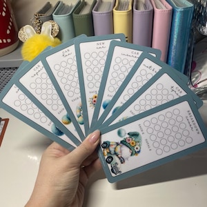 May include: A set of six blue and white printable car expense trackers. Each tracker has a different category: car repair, car tax, new car, car insurance, MOT & services, and car breakdown cover. Each tracker has a grid of circles for tracking expenses.