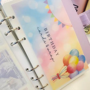May include: A planner insert with a colourful design for birthday cards and wrap. The insert features a pastel gradient background with balloons and a banner. The text "BIRTHDAY cards & wrap" is written in a script font.
