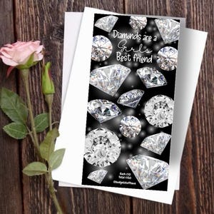 Peut inclure: Graphique noir et blanc avec le texte "Diamonds are a Girl's Best Friend" et des diamants. Une rose rose et une carte blanche sur une surface en bois.