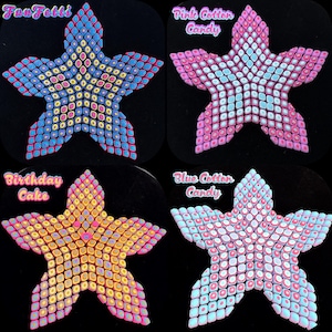 May include: Four star-shaped polymer clay creations. The first is blue with yellow and pink accents and says "Faux Fetti". The second is pink with white and blue accents and says "Pink Cotton Candy". The third is yellow with pink and blue accents and says "Birthday Cake". The fourth is blue with white and pink accents and says "Blue Cotton Candy".