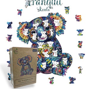 Op de afbeelding: Een kleurrijke legpuzzel met een gedetailleerd koala-ontwerp en de tekst "The Tranquil Koala". De puzzelstukjes zijn verspreid rond een grote koala-illustratie. Een doos met de puzzelafbeelding is ook zichtbaar.