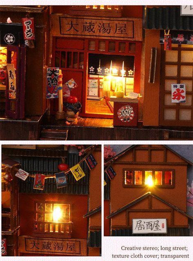 K&ouml;nnte beinhalten: Eine Miniatur-japanische Stra&szlig;enszene mit beleuchteten Geb&auml;uden, Schildern und Laternen. Die Szene umfasst ein Ramen-Restaurant und eine Bar mit detaillierten architektonischen Elementen und japanischem Text. Das Farbschema ist warm, mit beleuchteten Innenr&auml;umen.