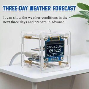 May include: A clear, cube-shaped weather forecast device with a digital display showing the date and time. The text "THREE-DAY WEATHER FORECAST" is at the top. The device is on a white surface.