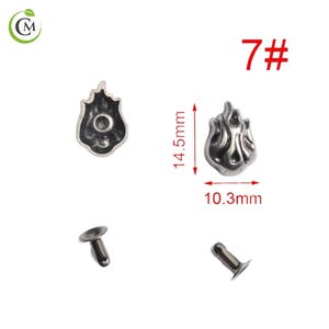 K&ouml;nnte beinhalten: Silberfarbene Metallnieten in Flammenform. Die Nieten messen 1,45 cm in der H&ouml;he und 1,03 cm in der Breite. Die Nummer 7# ist rot auf der oberen rechten Seite aufgedruckt. Zum Befestigen an Stoff oder Leder.