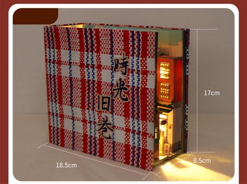 May include: A red and white chequered book-style miniature building with a lit interior. The building is 17 cm tall, 18.5 cm wide, and 8.5 cm deep. The building has a sign that reads "時光旧巷".