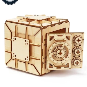 May include: A wooden model of a safe with a working door and a combination lock. The safe is made of light brown wood and has a detailed design. The door is open and the lock is visible. The safe is a fun and challenging project for anyone who enjoys woodworking.