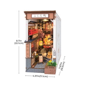 May include: A miniature Japanese street scene model, measuring 8.7 inches (22.1 cm) high, 4.37 inches (11.1 cm) wide, and 7.67 inches (19.5 cm) deep. The model features detailed buildings, lanterns, and cherry blossom accents, with Japanese text on the sign.