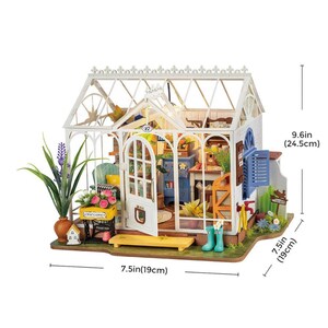 May include: A miniature white greenhouse with a glass roof and open door, showcasing a detailed interior. The model includes miniature furniture, plants, and accessories. The dimensions are 7.5 inches (19 cm) wide and 9.6 inches (24.5 cm) tall.