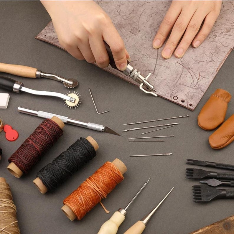 May include: A set of leather crafting tools including needles, awls, thread, a stitching pony, and a leather hole punch.