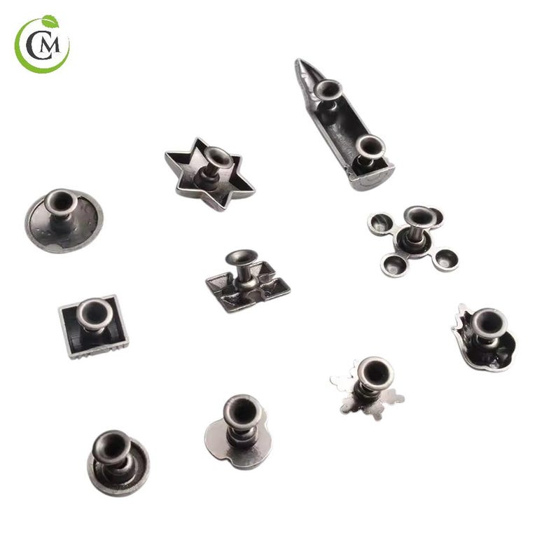 K&ouml;nnte beinhalten: Eine Sammlung von silberfarbenen Metallnieten in verschiedenen Formen, darunter ein Stern, ein Quadrat und eine Blume. Die Nieten haben ein Stift- und Kappendesign, geeignet zum Befestigen an Stoff oder Leder. Die Nieten sind auf einer wei&szlig;en Oberfl&auml;che verstreut.