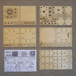 May include: A wooden safe box kit with instructions and laser-cut pieces. The kit includes a safe box, a lock, and a key. The safe box is made of wood and has a metal lock. The kit is designed to be assembled by hand.