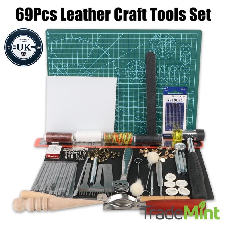 Peut inclure: Un ensemble d'outils de travail du cuir de 69 pi&egrave;ces avec un tapis de coupe vert, un outil de travail du cuir noir, un morceau de cuir blanc et une vari&eacute;t&eacute; d'aiguilles, d'al&egrave;nes et d'autres outils.