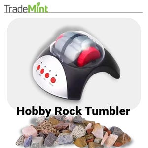 May include: A black and silver electric rock tumbler with a clear lid. The tumbler has four red buttons labeled "Rough", "Fine 1", "Fine 2", and "Polishing". The tumbler is sitting on a white surface with a pile of colorful rocks in the foreground.