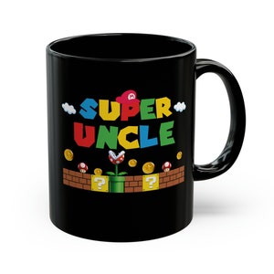 Puede incluir: Taza de café de cerámica negra con un gráfico blanco, amarillo, rojo, verde y azul que dice "SUPER UNCLE" con un diseño de hongo y signo de interrogación.