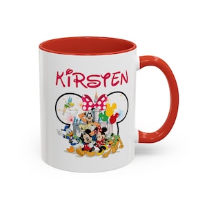 Puede incluir: Taza de cer&aacute;mica blanca con interior y asa rojos. La taza presenta un dise&ntilde;o tem&aacute;tico de Disney con Mickey y Minnie Mouse, Donald Duck y Goofy. El nombre "Kirsten" est&aacute; impreso en rosa encima de los personajes.