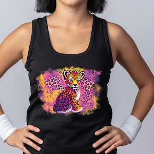 May include: Black tank top featuring a colorful illustration of a jaguar cub. The design includes a vibrant mix of pink, purple, yellow, and orange hues, with a leopard print background. The jaguar cub has a detailed, cartoon-like appearance.