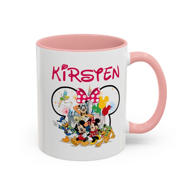 Puede incluir: Taza de cer&aacute;mica blanca con interior y asa rosas. La taza presenta un dise&ntilde;o tem&aacute;tico de Disney con Mickey y Minnie Mouse, el Pato Donald y Goofy. El nombre "Kirsten" est&aacute; impreso en rosa encima de los personajes.