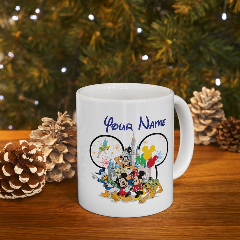 Puede incluir: Taza de cer&aacute;mica blanca con un dise&ntilde;o de personajes de Disney y el texto "Your Name". El dise&ntilde;o incluye Mickey Mouse, Minnie Mouse, Donald Duck, Goofy y otros personajes. La taza tiene un asa curva.