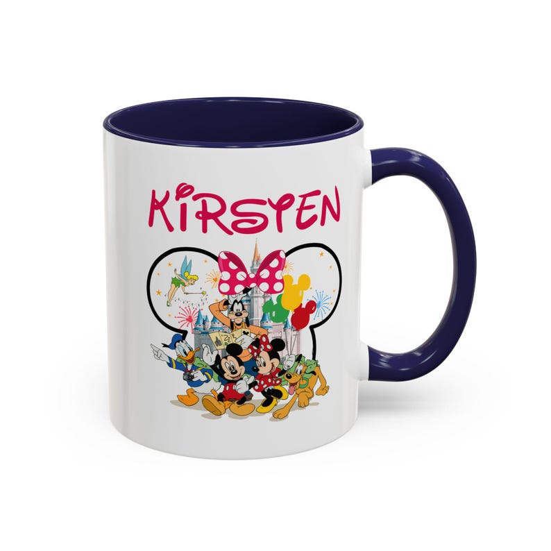 Puede incluir: Taza de cer&aacute;mica blanca con interior y asa azul marino. La taza presenta un gr&aacute;fico colorido de personajes de Disney, incluidos Mickey y Minnie Mouse, Donald Duck y Goofy. El nombre "Kirsten" est&aacute; impreso en rosa.
