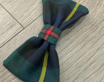 May include: A green, blue, and yellow plaid bow tie with a red and green plaid center.