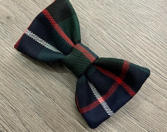 May include: A plaid bow tie in shades of green, red, and white. The bow tie is tied and ready to wear.