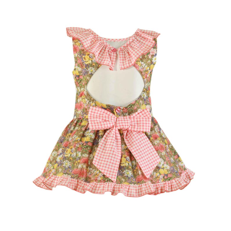 May include: A floral print dress with a pink gingham bow and trim. The dress features a ruffled neckline and a keyhole back. The fabric has a pattern of small flowers in various colours.