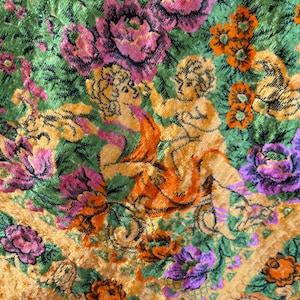 May include: A vintage tapestry with a gold background and a floral pattern. The tapestry features two cherubs in the centre, surrounded by flowers in shades of pink, purple, orange, and green.