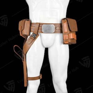 May include: A brown leather utility belt with multiple pouches and a holster. The belt features a silver buckle and a leg strap. The pouches are various sizes and shapes, and the holster is designed to hold a weapon. The belt is designed to be worn around the waist and thigh.