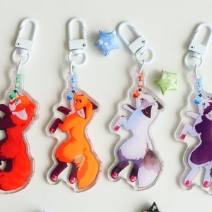 Puede incluir: Cuatro llaveros de acrílico coloridos con personajes de animales de dibujos animados. Cada llavero tiene un cierre de metal blanco y una cuerda colorida con una pequeña cuenta al final. Los personajes son un panda rojo, un zorro, un lobo blanco y gris y un lobo morado.