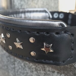 Puede incluir: Collar de perro de cuero negro con detalles de estrellas plateadas y tachuelas plateadas.