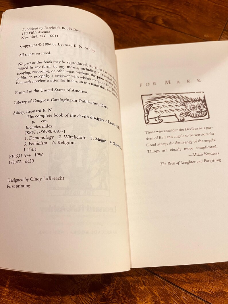 Pu&ograve; includere: Pagine di un libro aperto con testo e illustrazioni. La pagina di sinistra elenca le informazioni sulla pubblicazione, i dettagli sul copyright e i dati della Library of Congress. La pagina di destra presenta un disegno e una citazione da Milan Kundera.