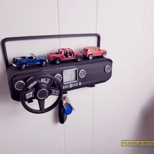 Show off your Jeep style with this fun and functional Duck Duck Jeep Display!

It holds 4 vending machine rubber ducks or 3 Hot Wheels cars, features a light-up front dash for extra flair, hidden storage for sunglasses or other small items, and 3 removable key hooks. Mount it on the wall or set it on a dresser or shelf—either way, it’s the perfect gift for Jeep lovers, Hot Wheels collectors, and ducking enthusiasts who want to organize in style!