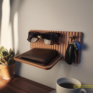 May include: A wooden wall-mounted organizer with a shelf, key hooks, and a sunglasses holder. The organizer holds a brown leather wallet, tortoiseshell sunglasses, and keys. A small potted succulent and a cup of coffee are also visible.