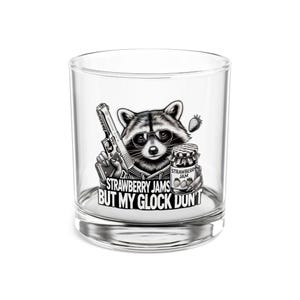 May include: A clear glass tumbler with a black and white illustration of a raccoon holding a gun and a jar of strawberry jam. The text "Strawberry Jams But My Glock Don't" is printed on the glass.