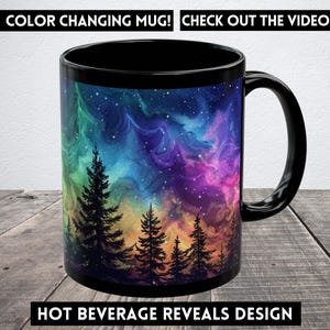 May include: A black color-changing mug with a design of a colorful galaxy and trees. The mug changes color when a hot beverage is poured into it. "COLOR CHANGING MUG! CHECK OUT THE VIDEO" and "HOT BEVERAGE REVEALS DESIGN" are printed on the image.