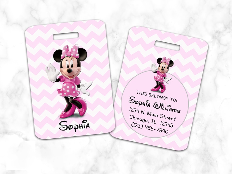 Pode incluir: Etiqueta de bagagem rosa com uma imagem de desenho animado do Mickey Mouse. A etiqueta tem um padr&atilde;o de chevron branco e o texto "THIS BELONGS TO: SOPHIA WILLIAMS 1234 N. Main Street Chicago, IL 12345 (123) 456-7890".