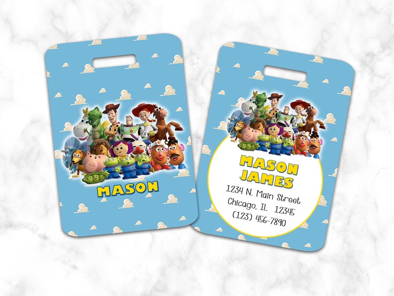 Puede incluir: Etiqueta de equipaje con tem&aacute;tica de Toy Story con fondo azul y nubes blancas. La etiqueta presenta un grupo de personajes de Toy Story, incluyendo a Woody, Buzz Lightyear, Jessie y Mr. Potato Head. La etiqueta tiene un c&iacute;rculo amarillo con el texto "MASON JAMES" e informaci&oacute;n de contacto.