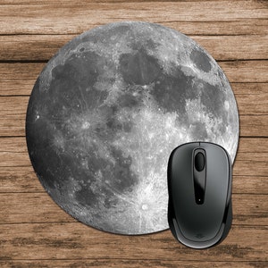 Op de afbeelding: Een zwarte computermuis op een ronde muismat met een gedetailleerd beeld van de maan.