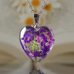 A transparent heart-shaped resin pendant with a delicate alyssum flower. Real Flower Necklace, Resin Jewelry, Botanical jewelry.